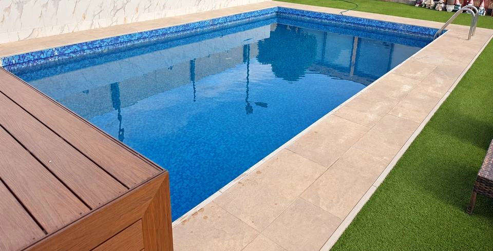 Piscina con terraza de madera y jardín