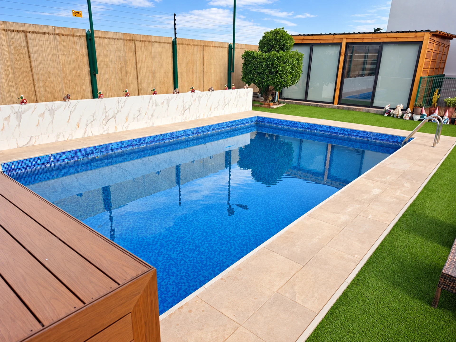 Piscina rodeada de una terraza y jardín para disfrutar al aire libre